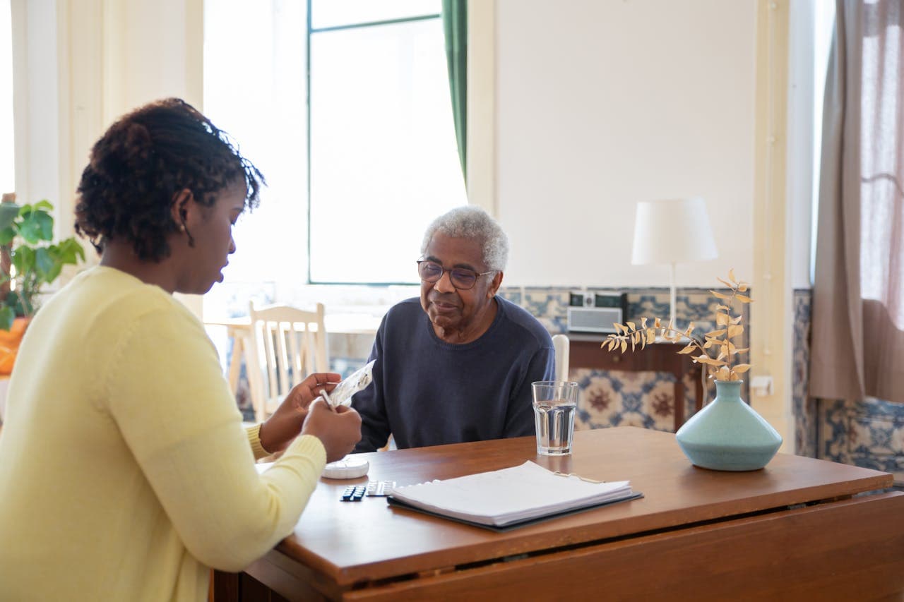 A community health worker meeting with an older adult at home